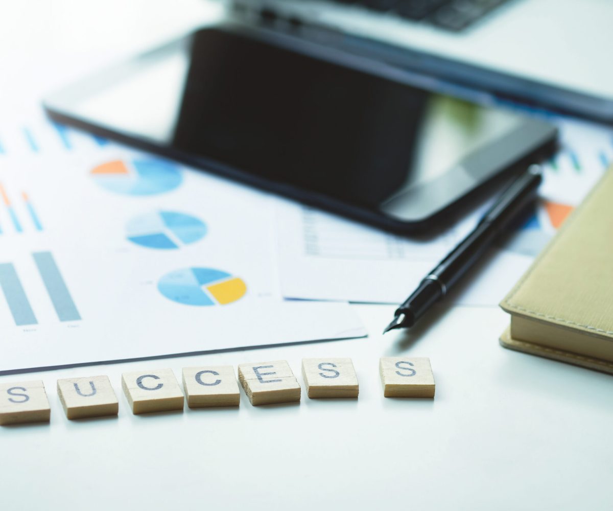 “Success” word on business working table. Wooden cross word alphabet “Success”. Business success concept.